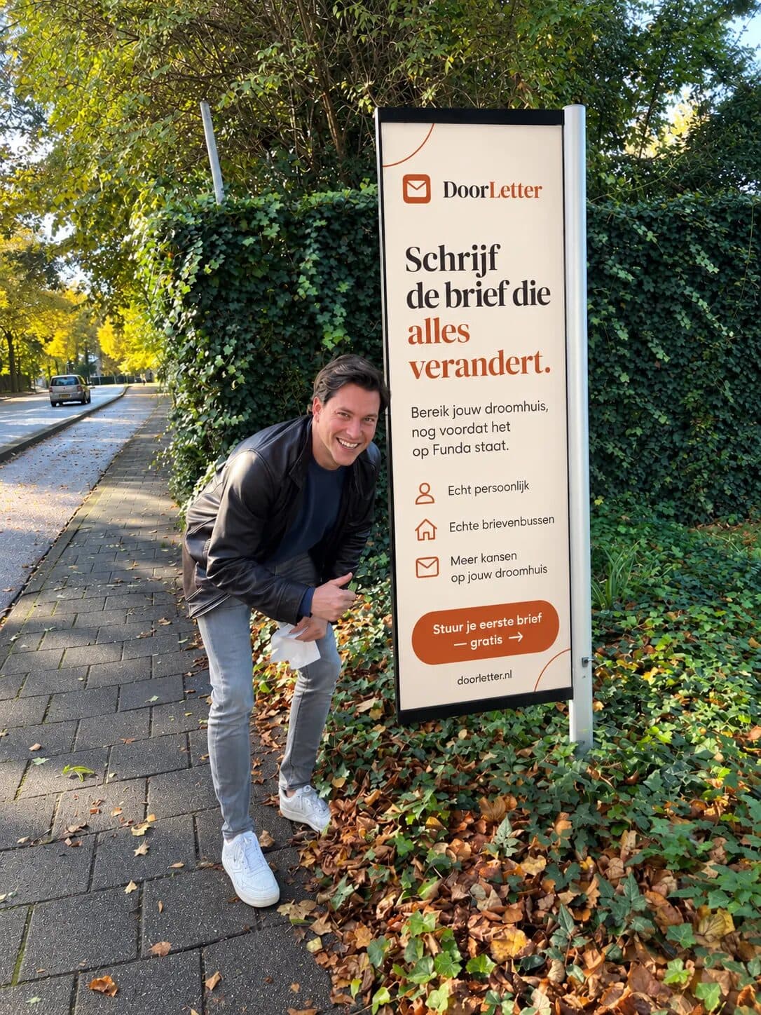 Jiri, estate agent and founder of DoorLetter, next to a DoorLetter sign